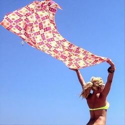 Low angle view of woman against blue sky