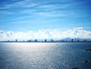 Scenic view of sea by city against sky