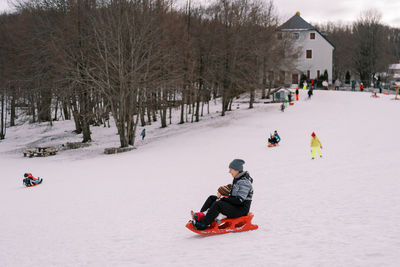 People skiing on snow covered field