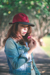 Portrait of smiling woman standing against tree