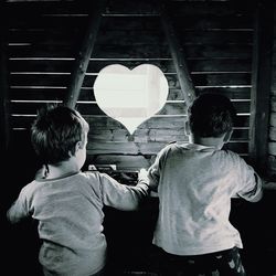 Rear view of siblings playing at home