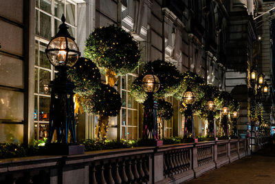 Illuminated street amidst buildings in city at night