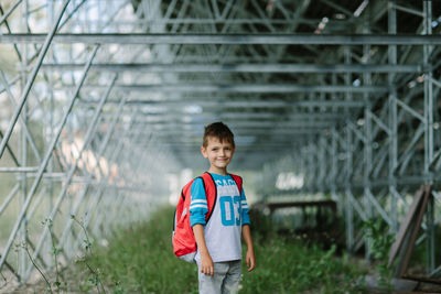 Portrait of boy standing in greenhouse