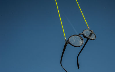 High angle view of eyeglasses against blue sky