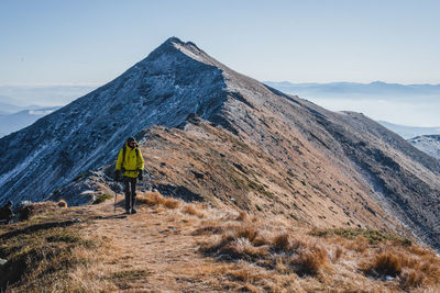 Rear view of man on mountain against sky