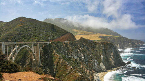 Scenic view of bridge over mountains against sky