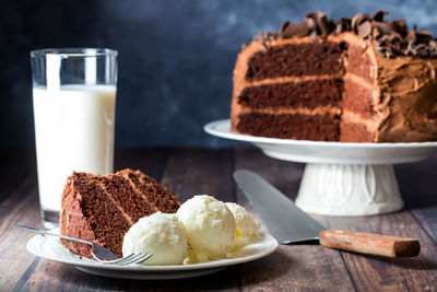 Triple layered decadent chocolate cake with one slice served with ice cream