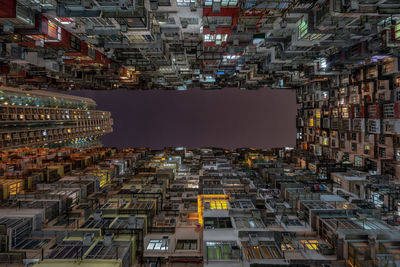 Directly below shot of illuminated buildings against sky at night