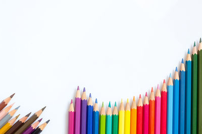 Close-up of multi colored pencils against white background