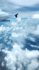 Aerial view of airplane wing over clouds