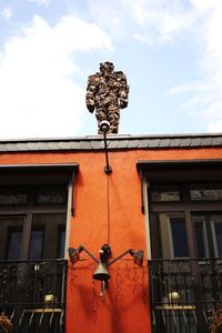 Low angle view of sculpture on building against sky