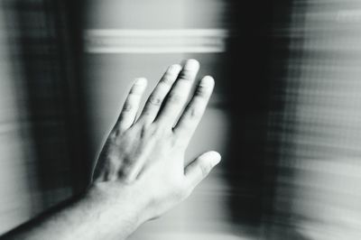 Cropped hand by window