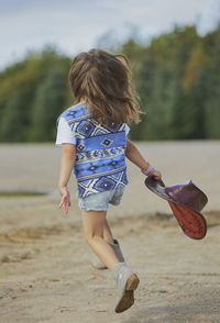 Full length of young woman standing at beach