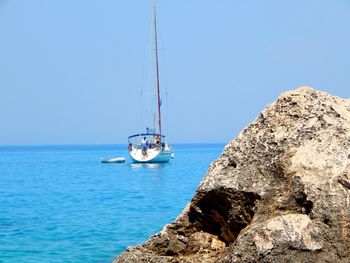 Sailboats sailing in sea against clear blue sky