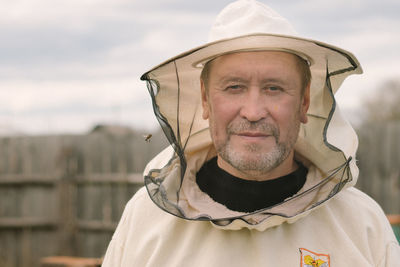 Closeup portrait of a beekeeper in mask with a bee