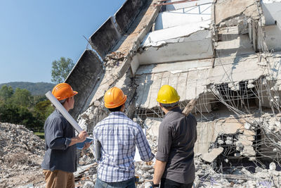 Rear view of people standing against building