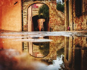 Reflection of old building in puddle