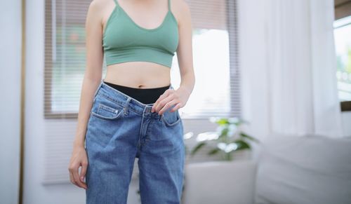 Midsection of woman standing in bathroom