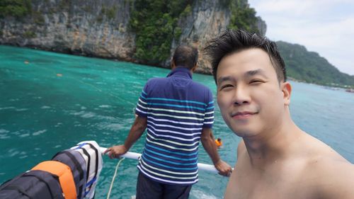 Portrait of shirtless man on boat in sea