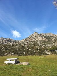 Scenic view of land and mountains against blue sky