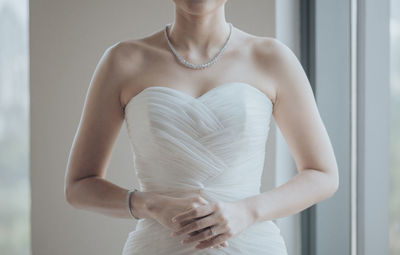 Midsection of bride standing at home