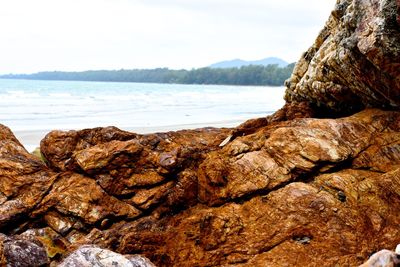 Close-up of rocks on shore against sky