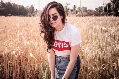 Beautiful young woman standing in field