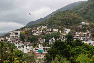High angle view of houses by mountains against sky