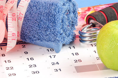 High angle view of towel with apple and tape measure on calendar