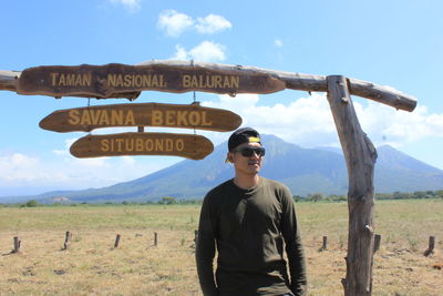 Young man standing on land against sky