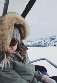 Full length of woman sitting in snow