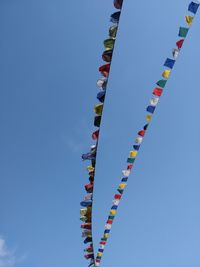 Low angle view of prayer flags against sky on sunny day