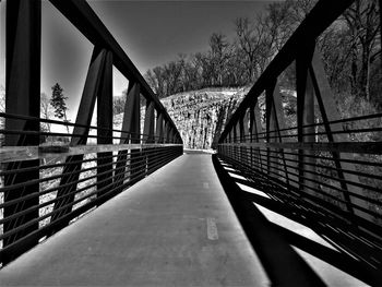 Empty footbridge against sky