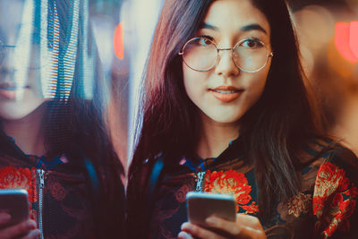 Portrait of young woman using smart phone outdoors