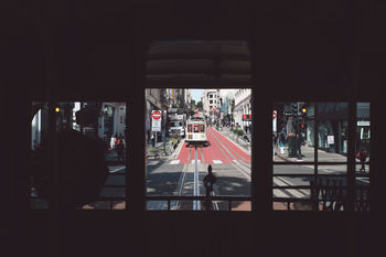 PEOPLE IN ILLUMINATED CITY AT NIGHT SEEN THROUGH BUS