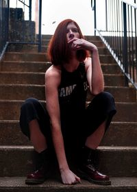 Full length of woman sitting on staircase