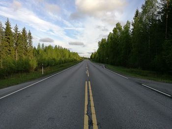 Empty road against cloudy sky