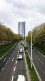 Cars on road in city against sky