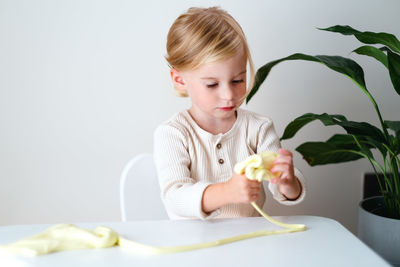 Girl playing with slime on table