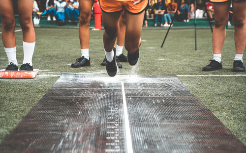 Low section of boy jumping playing at field