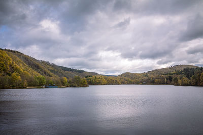 Scenic view of lake by mountain against sky