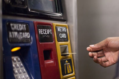 Cropped image of hand reaching for card at atm