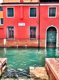 Buildings by swimming pool in canal