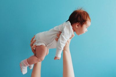 Cute boy standing against blue background