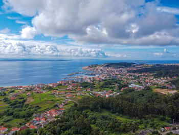 High angle view of townscape by sea against sky