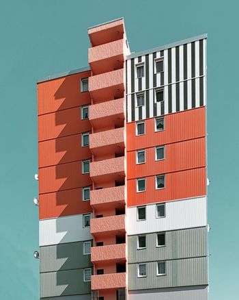 LOW ANGLE VIEW OF APARTMENT BUILDING AGAINST CLEAR SKY