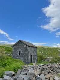 House on field against clear blue sky