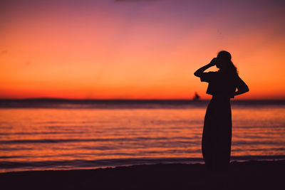 Silhouette woman standing at sunset
