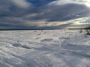 Scenic view of snow covered field against sky