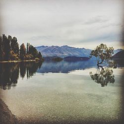 Scenic view of lake against cloudy sky